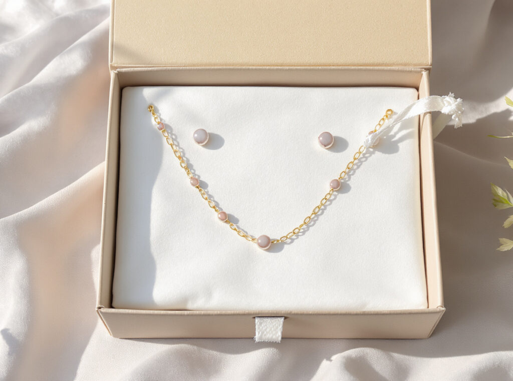 Jewelry set with dual packaging showing box for presentation and individual pouches for each piece